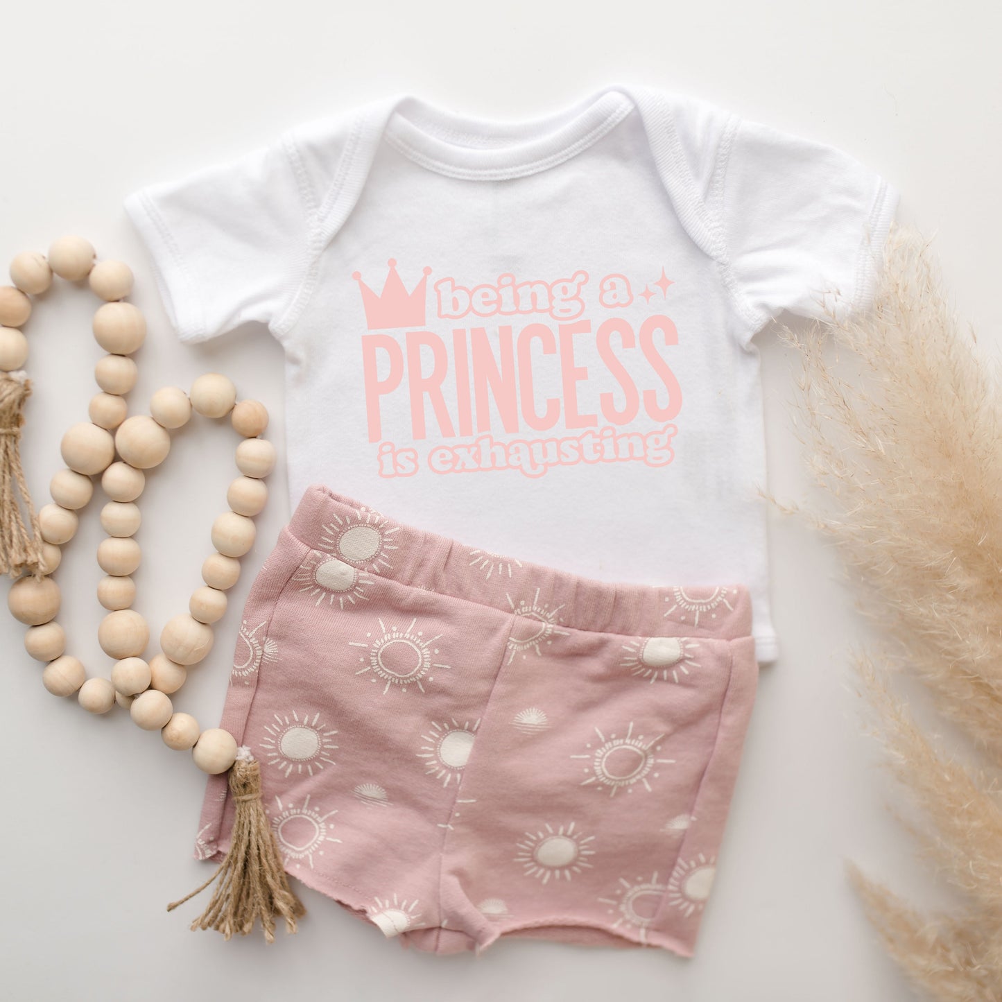 Being A Princess Is Exhausting | Baby Graphic Short Sleeve Onesie by The Juniper Shop